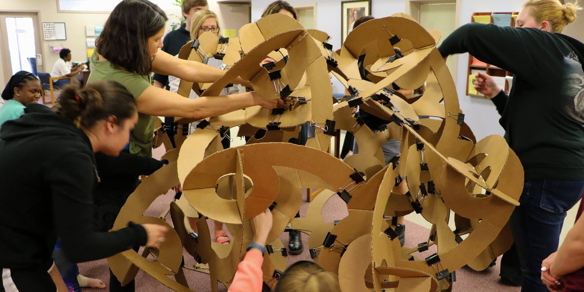 Students use cardboard and binder clips to build a sculpture